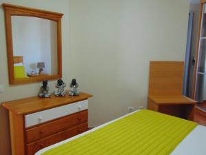 a bedroom with a yellow bed and a mirror at Aeropuerto in Carrizal