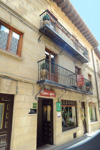 ein Gebäude mit einem Balkon und einem Gebäude mit einer Tür in der Unterkunft Legado de Ugarte, Casa Rural in Laguardia