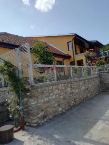 a stone fence in front of a house at Casa Darius in Orşova