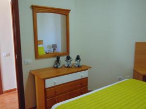 a bedroom with a bed and a mirror on a dresser at Aeropuerto in Carrizal