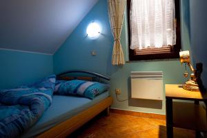 niebieska sypialnia z łóżkiem w pokoju w obiekcie Zidanica Meglič - Vineyard cottage Meglič w mieście Trebnje