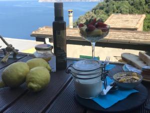 a table with a bowl of fruit and a glass of wine at il Magàn - Cinque Terre in Corniglia