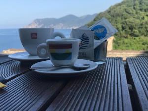 two coffee cups and a box on a wooden table at il Magàn - Cinque Terre in Corniglia