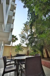 a table and chairs on a patio with trees at Suvidha Ghar AC DORMITORY in Surat