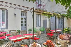 een patio met tafels, stoelen en planten bij Anne de la Maison Blanche in Avignon