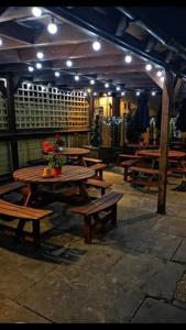 un grupo de mesas y bancos de madera en un restaurante en The Old Ship Inn, en Dorchester