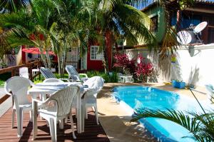 a table and chairs next to a swimming pool at Pousada Luzes de Geribá in Búzios