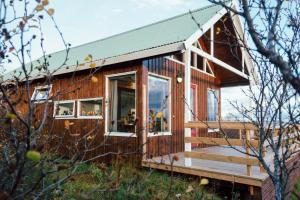 una casa in legno con portico e finestra di Mulakot Cosy Cabins a Borgarnes