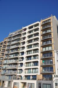 een groot appartementencomplex met balkons bij Place 2 SEA - Appartement frontaal zeezicht - strand - Zeedijk - nabij Brugge in Blankenberge