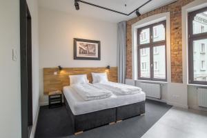 sypialnia z łóżkiem i ceglaną ścianą w obiekcie Loft Apartments Poznań w Poznaniu