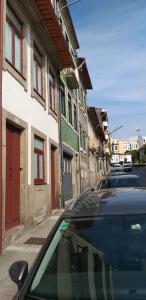 two cars parked on a city street with buildings at Casa Barão Forrester in Porto