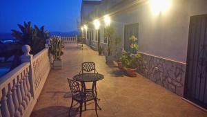 patio z 2 krzesłami i stołem na balkonie w nocy w obiekcie Casa Barranca Holiday Apartments w mieście Santa María de Nieva