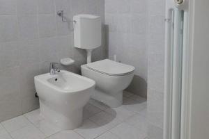 La salle de bains blanche est pourvue de toilettes et d'un bidet. dans l'établissement Ca di baragett, à Mandello del Lario
