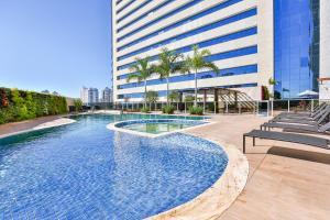 a swimming pool in front of a tall building at Transamerica Collection Goiânia in Goiânia