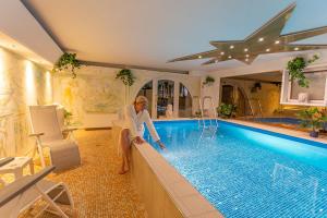 a man sitting in front of a swimming pool at Hotel Im Schwedischen Hof in Binz