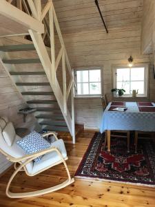 een kamer met een tafel, een stoel en een trap bij Sjöbacken Gård in Lerdala