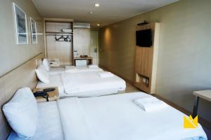 a room with four beds and a tv in it at Brasília Imperial Hotel e Eventos in Brasilia