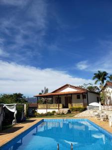 una casa con piscina frente a ella en Pousada Canto Verde, en Serra do Cipo