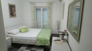 a white bedroom with a bed and a mirror at Summer Breeze Cavtat in Cavtat