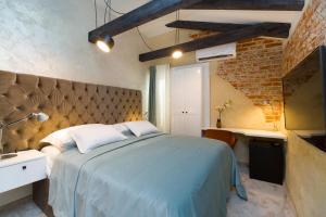 a bedroom with a large bed and a brick wall at LAmenta in Split