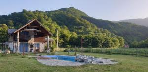 a house with a pool in front of a mountain at Exo Log Cottage in Jezero