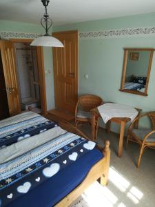 1 dormitorio con cama, mesa y espejo en Hanslbauernhof en Moosbach