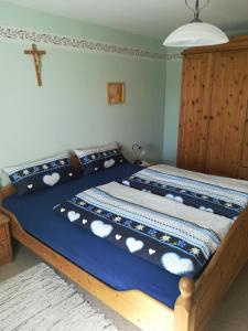 un letto in una camera da letto con una croce sul muro di Hanslbauernhof a Moosbach