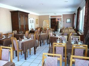 a dining room filled with tables and chairs at Hôtel de France in Isigny-sur-Mer