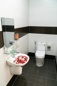 a bathroom with a toilet and a sink with flowers on it at Golden Soulmate homestay in Hoi An