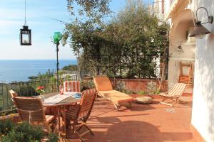 a patio with a table and chairs and the ocean at Villa Flora in Vico Equense