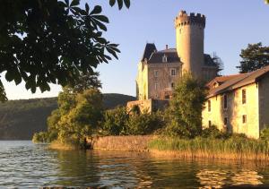 a castle on the shore of a body of water at Art_Booking . . . by Benoit_B in Duingt