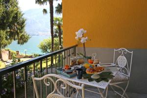 una mesa con una bandeja de comida en el balcón en Apartment A lago, private beach and parking, en Oliveto Lario