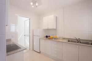 a white kitchen with a sink and a refrigerator at Cabot Siller Apartment in Port de Pollensa