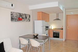 cocina y comedor con mesa y sillas en Apartamentos Doña Carmen 3000, en Oropesa del Mar