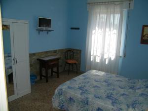 een slaapkamer met een bed, een bureau en een raam bij Home89 in Lucca