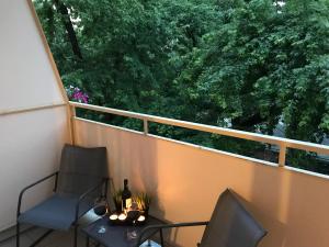 balcón con 2 sillas, mesa y ventana en Rent0nline Hoża Apartment Center Metro, en Varsovia