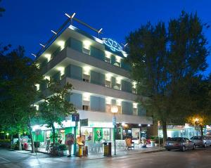 a building with a sign on top of it at night at Residence Sangiorgi in Cattolica