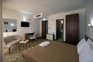 una camera d'albergo con letto e divano di Hotel Nar Gevgelija a Gevgelija