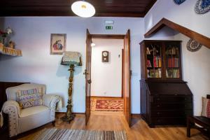 a living room with a chair and a book shelf at Lagar do Sapateiro in Fontes