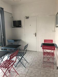 a room with two tables and chairs and a door at Hôtel Le Pescadou in Argelès-sur-Mer