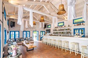 un restaurante con un bar con mesas y sillas en Cape North West, en Parga