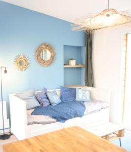 - un canapé blanc avec des oreillers dans l'établissement Superbe Maison 4 personnes entre le port et le centre, COUR PRIVATIVE, WiFi & Netflix gratuits, à Saint-Brieuc