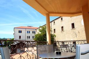 einen Balkon mit einem Tisch und Stühlen sowie ein Gebäude in der Unterkunft DOLCE VITA in Tempio Pausania