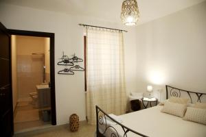 ein Schlafzimmer mit einem Bett und ein Badezimmer mit einer Dusche in der Unterkunft DOLCE VITA in Tempio Pausania
