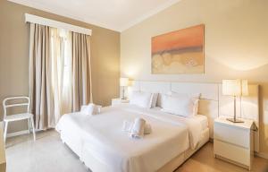 a hotel room with a large white bed and a window at Cape North West in Parga