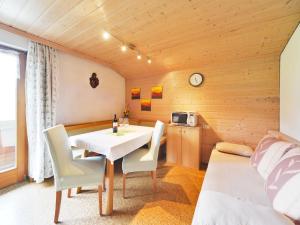 a dining room with a white table and chairs at Pension Oberhauser in Schoppernau
