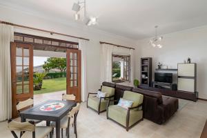 uma sala de estar com um sofá e uma mesa em Southern Sunny House by An Island Apart na Calheta