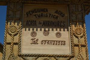 a sign on the side of a building with writing on it at Acasa in Maramures in Fereşti