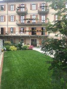 ボルミオにあるHOTEL AD Residenceの緑の芝生が目の前に広がるアパートメントビル