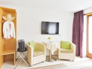 Cette chambre dispose d'une table, de deux chaises et d'une télévision. dans l'établissement Haus Oberhauser, à Schoppernau